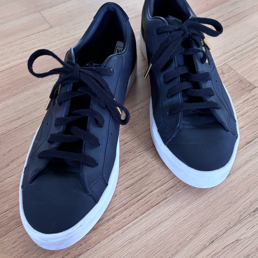 Adidas “sleek” women’s black leather casual sneaker.